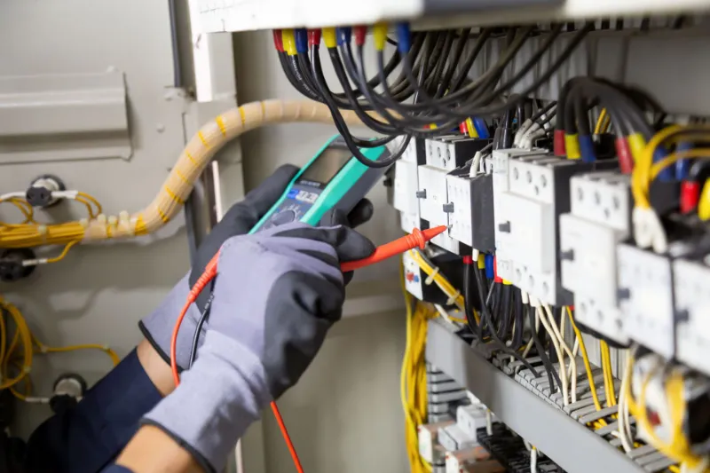 Elettricista al lavoro su un quadro elettrico